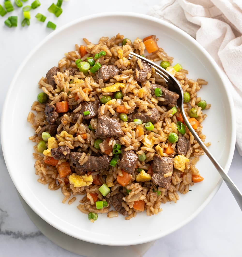 Beef Fried Rice on a white plate with a fork on the side.